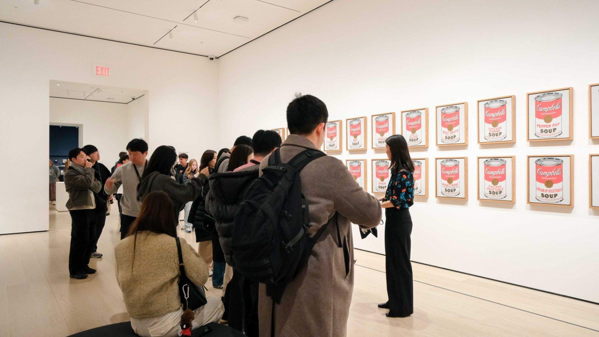 박물관 내부 벽에 걸린 그림과 이를 바라보는 사람