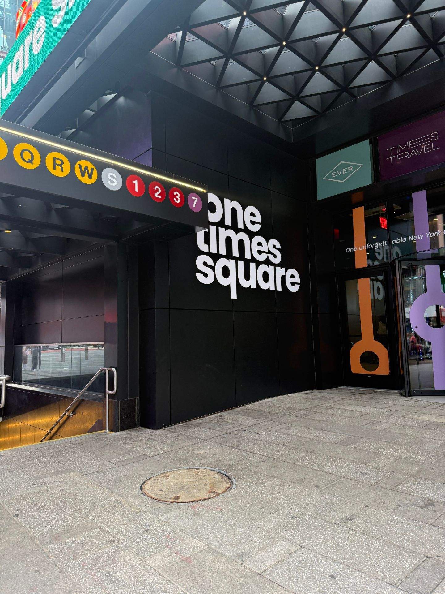 One Times Square 문구가 적힌 표지판과 계단이 있는 건물 입구 모습