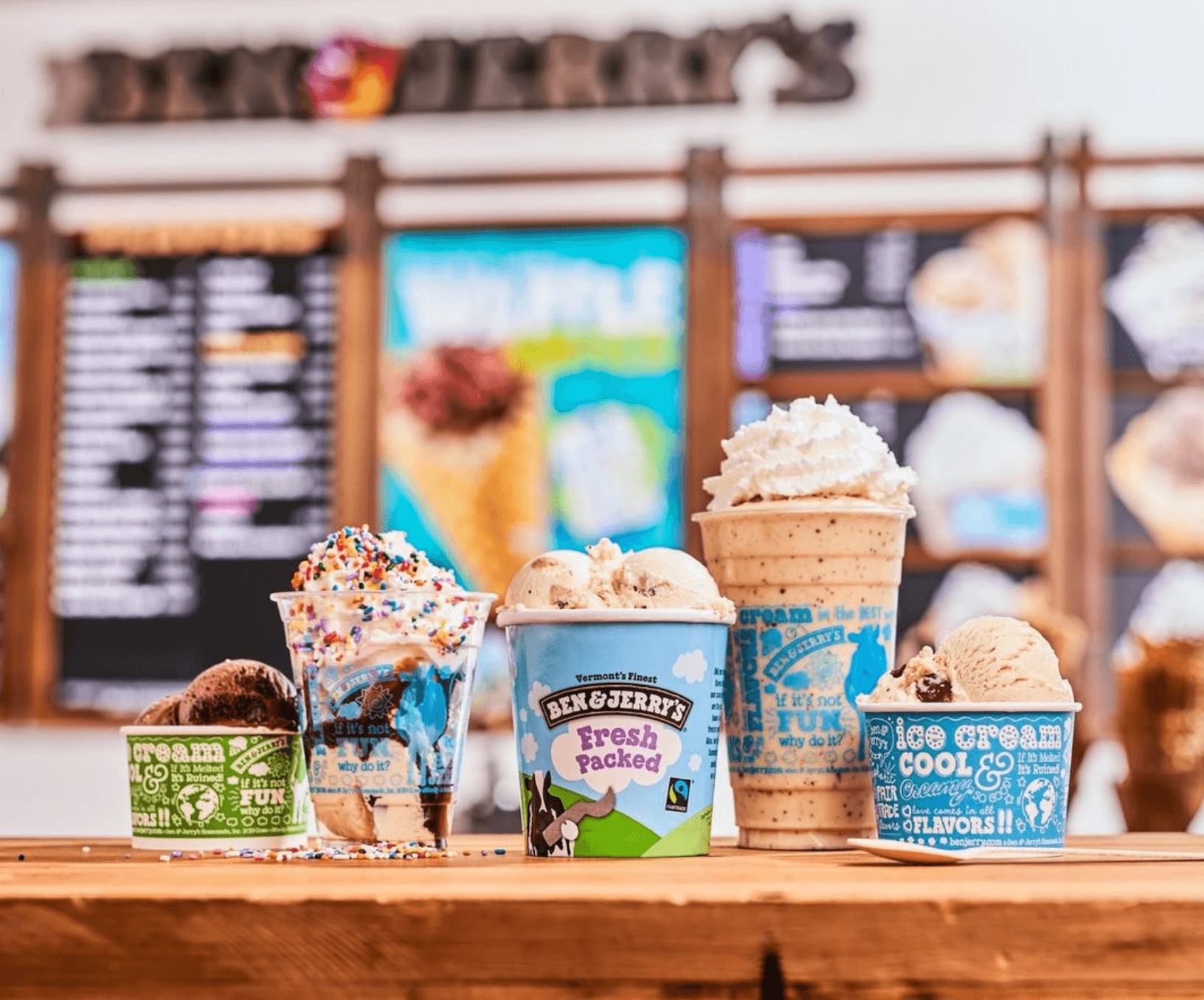 나무 테이블 위에 놓인 Ben & Jerry's 아이스크림 컵들