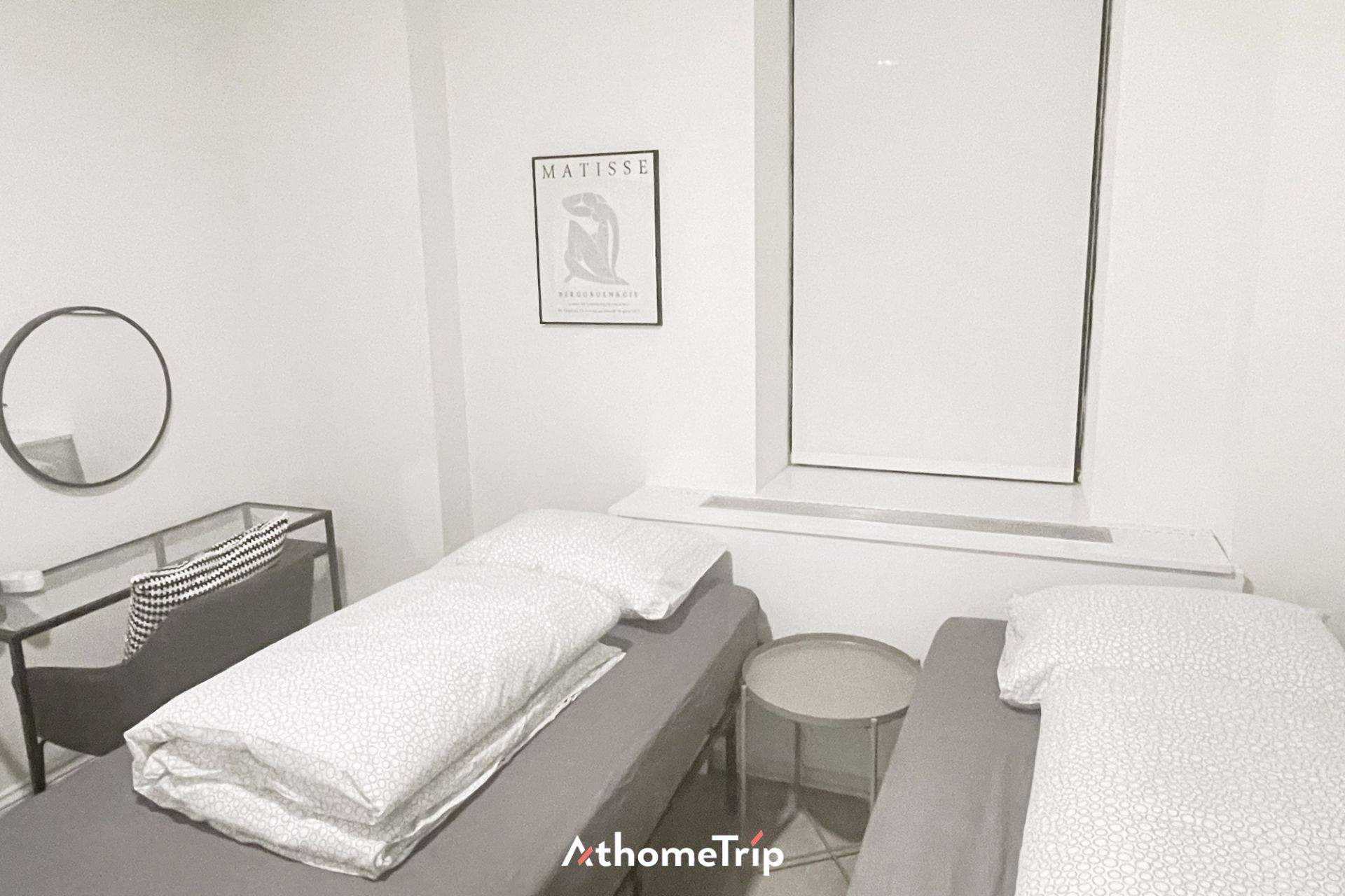 흰색 벽과 침대, 테이블과 그림이 있는 방 내부