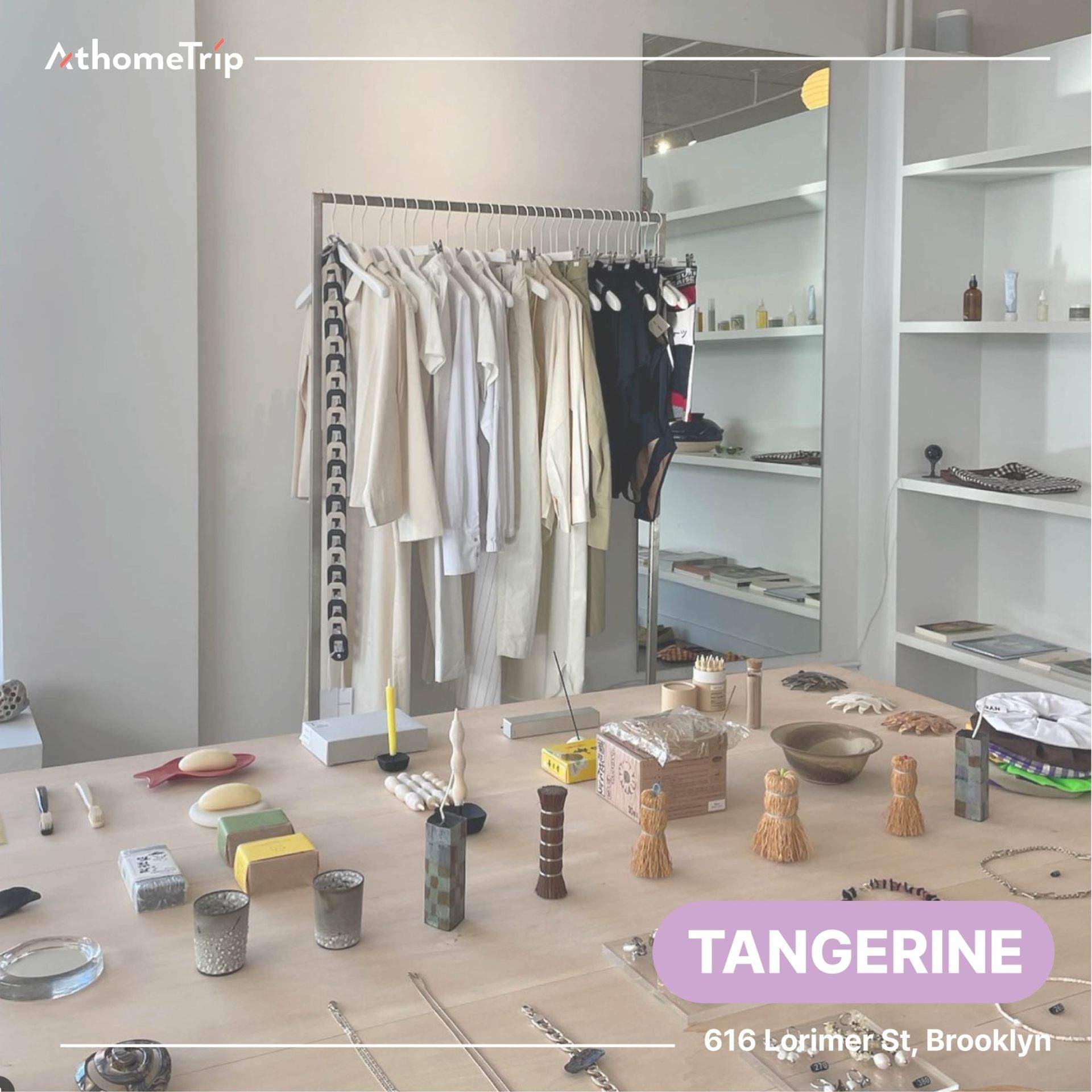 TANGERINE 문구가 보이는 실내 전시 공간에 옷걸이와 테이블 위의 접시, 병 등 소품이 배치된 모습