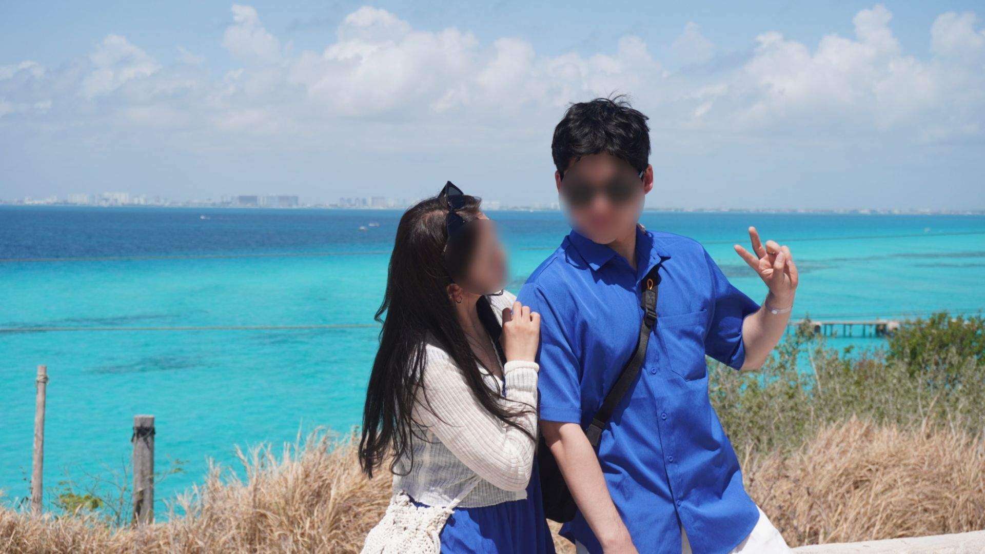 해변에 두 사람과 바다 그리고 하늘이 보이는 풍경