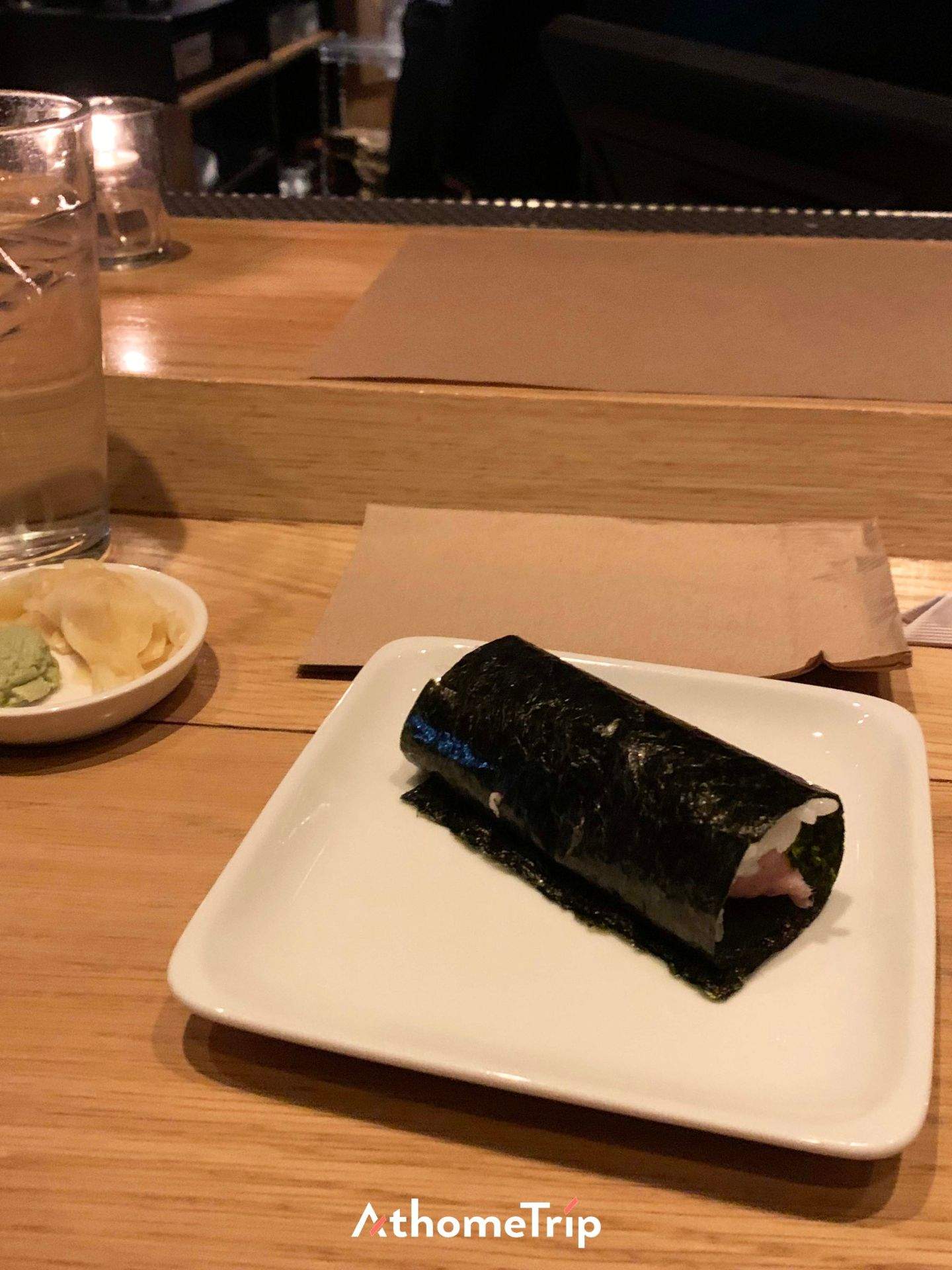 식탁 위에 김밥과 물병, 작은 접시가 함께 있는 장면