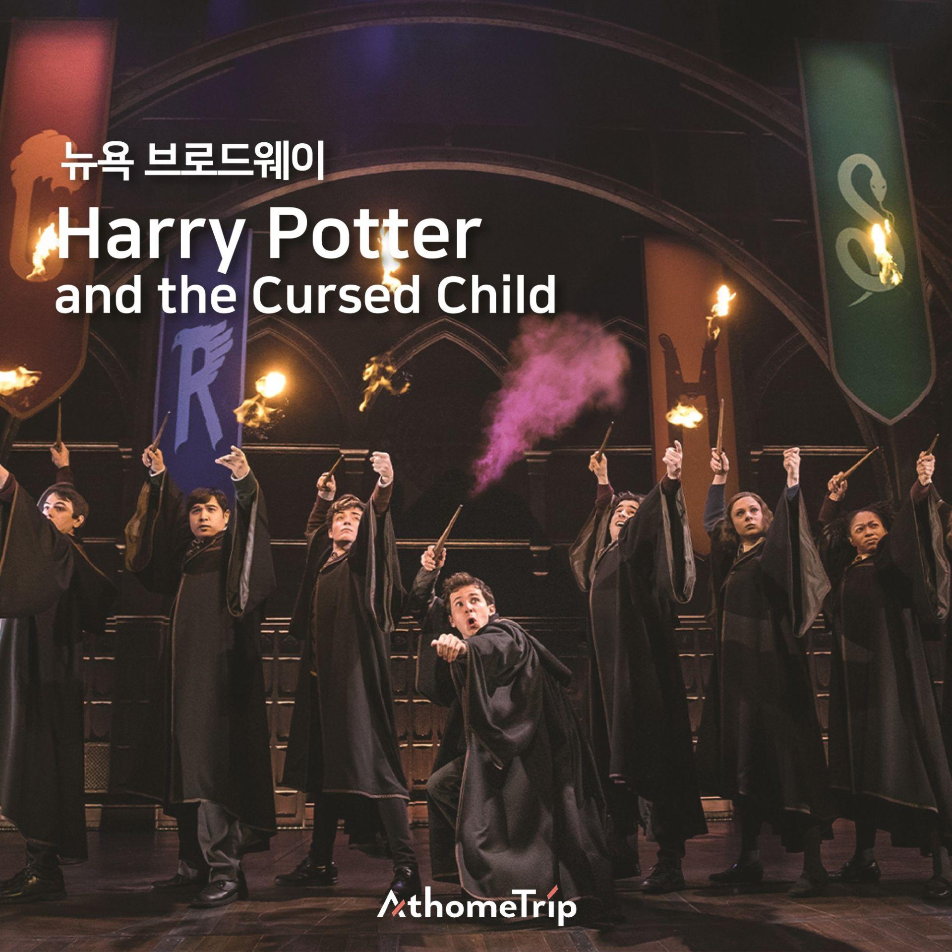 무대 위에 놓인 로브와 마법 지표, 뉴욕 브로드웨이 Harry Potter and the Cursed Child 문구가 보이는 실내 장면