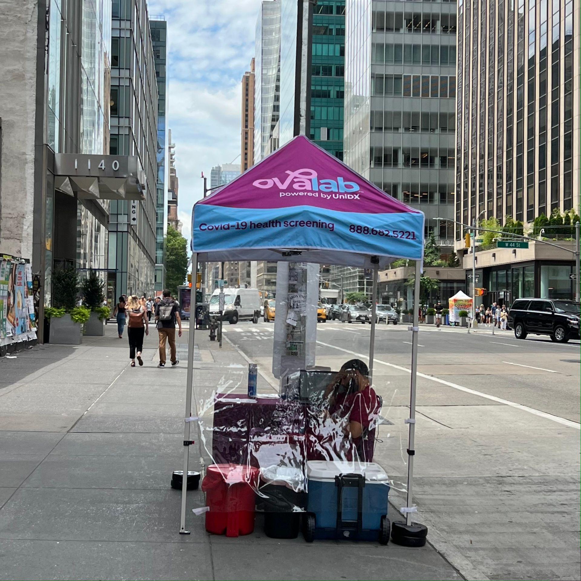 도시 건물과 차량이 보이는 거리의 코로나19 건강 검사 텐트 모습
