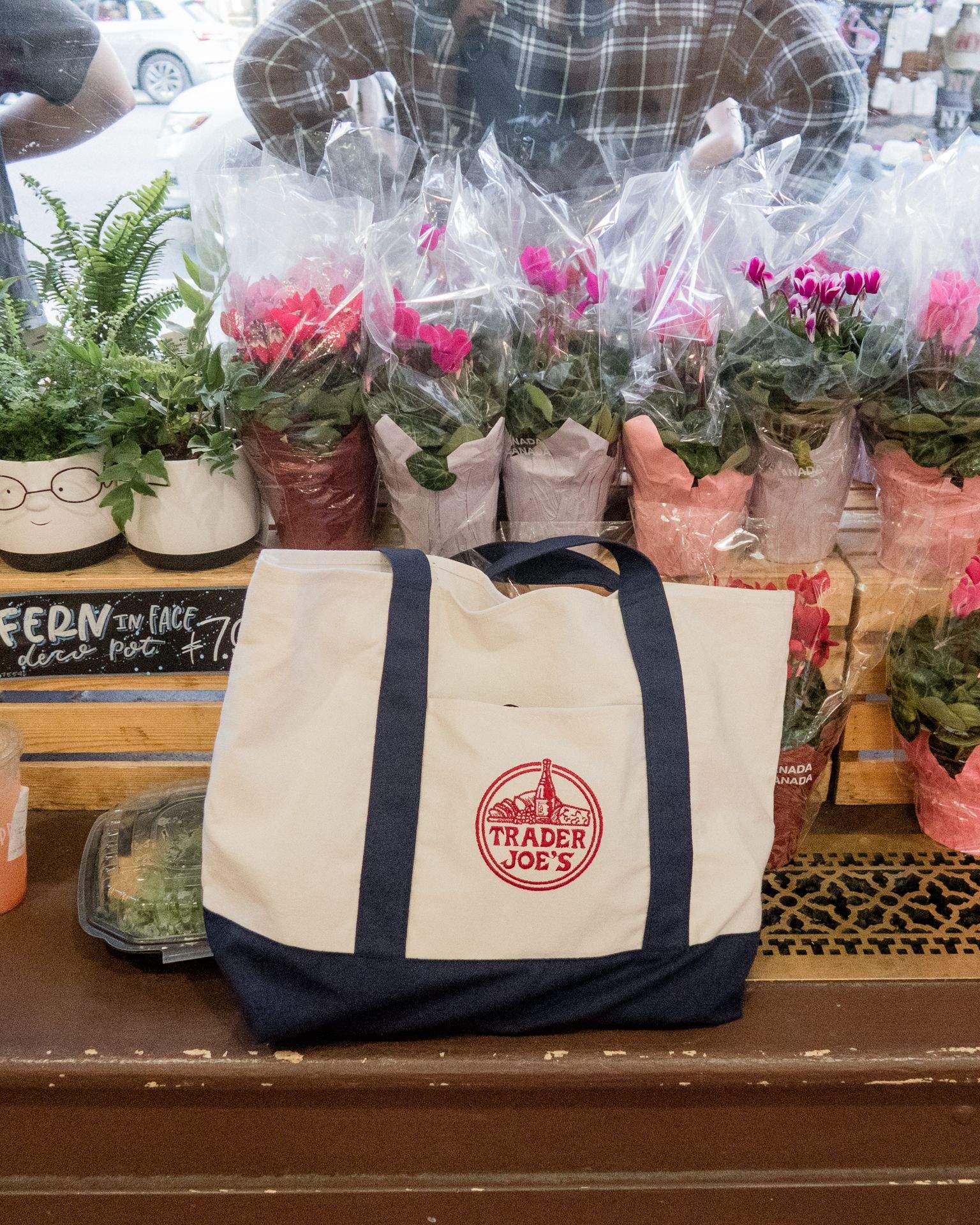 TRADER JOE'S 로고가 적힌 가방과 꽃다발이 놓인 모습