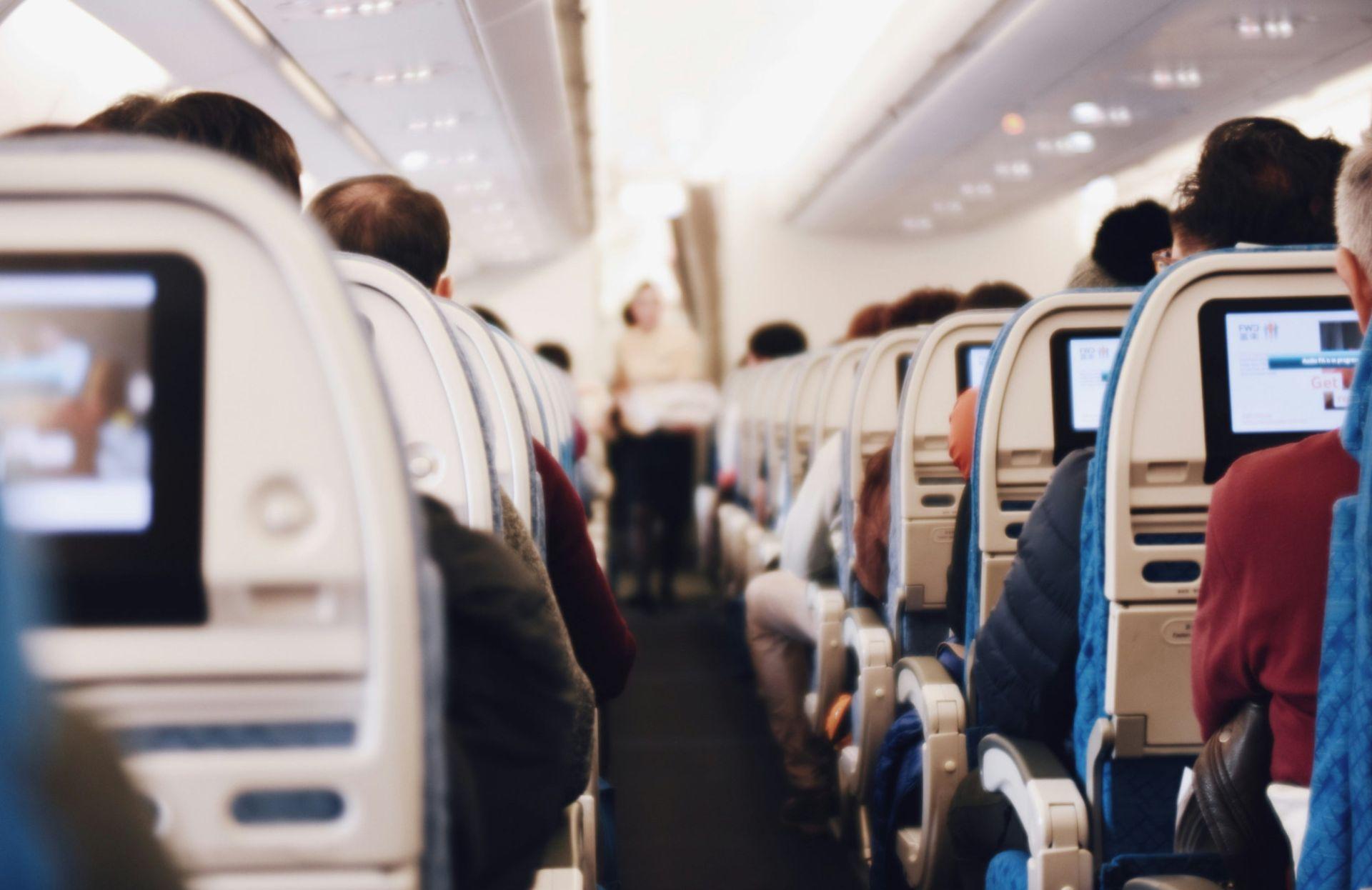 항공기 내부에 줄지어 있는 좌석과 화면이 보이는 실내 풍경
